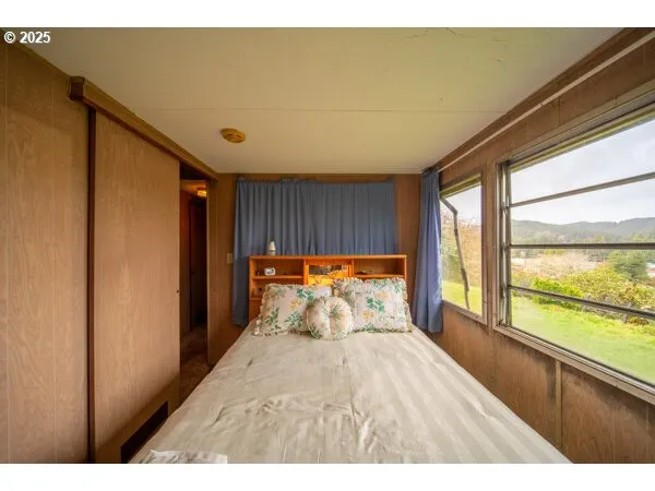 a bedroom with a bed and a dresser next to a window