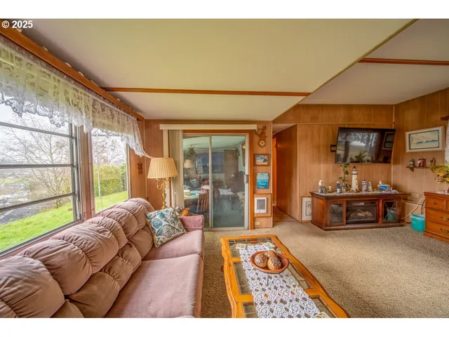 a living room with a large window and a wooden floor