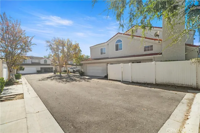 a view of a white house with a large space in front of it