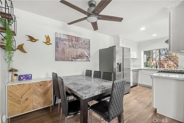 a kitchen with stainless steel appliances granite countertop a table chairs and a refrigerator