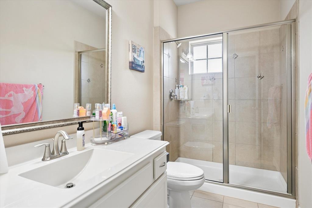 8268 Kara Creek Road Frisco, TX 75036 - Photo 16 of 31 Bathroom featuring a white vanity with integrated sink, brushed nickel faucet, and an ornate silver-framed mirror