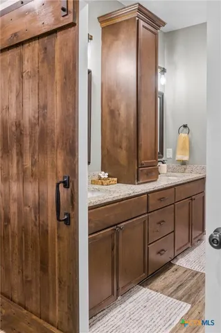a spacious bathroom with a granite countertop sink and a mirror