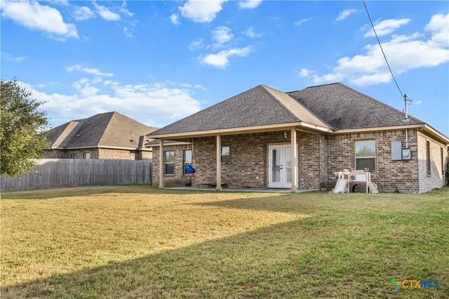 a view of a house with a yard and sitting area