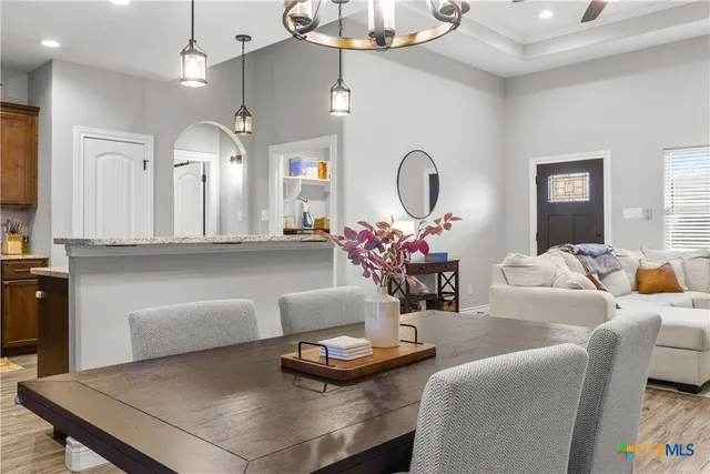 a living room with furniture a large window and a chandelier