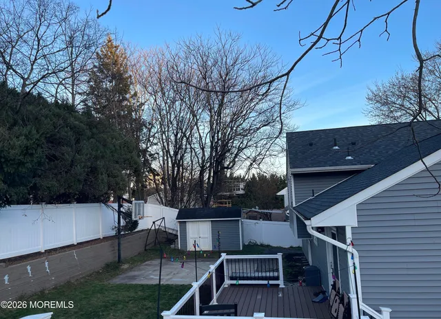 a view of backyard with wooden fence and trees