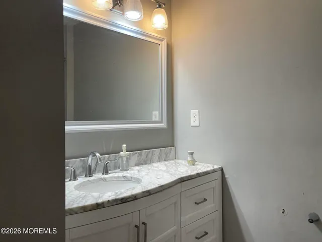 a bathroom with a granite countertop sink and a mirror