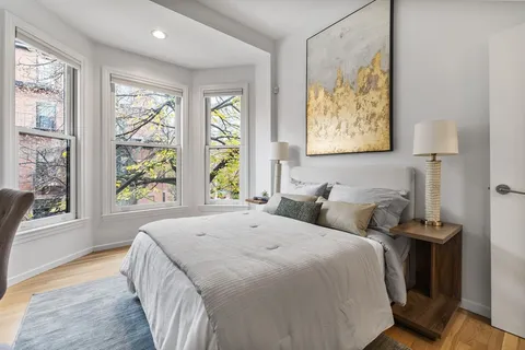 a bedroom with a bed and a large window