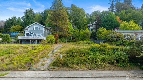 a view of a house with a yard and large trees