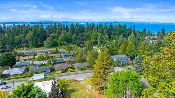 a view of a white house with large trees