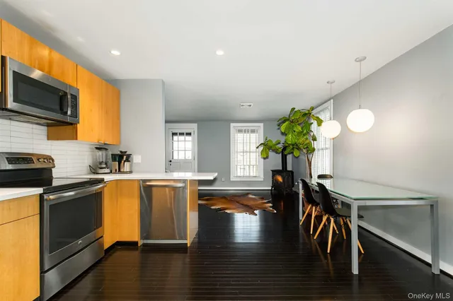 a kitchen with a refrigerator a stove top oven a sink and a window