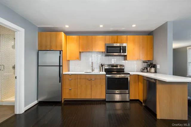 a kitchen with stainless steel appliances a table and chairs in it