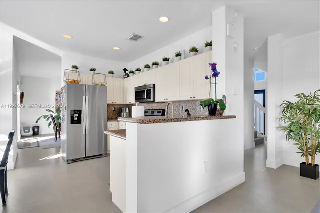 a view of kitchen with stainless steel appliances refrigerator and microwave