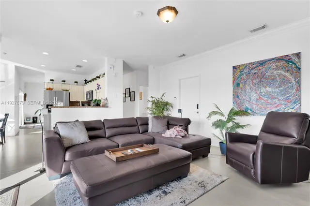 a living room with furniture and wooden floor