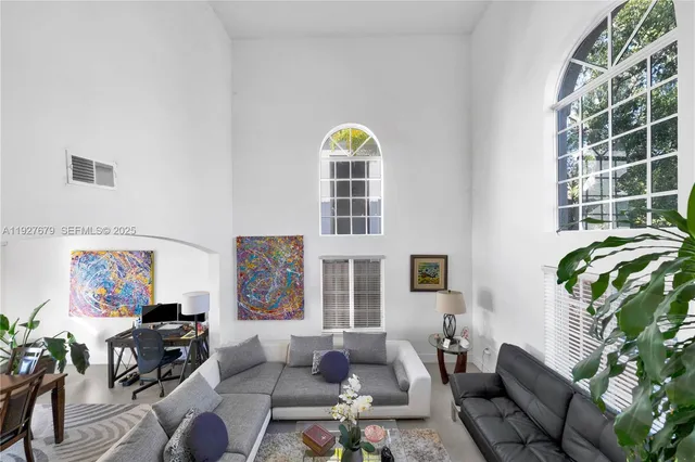 a living room with furniture a rug and a window