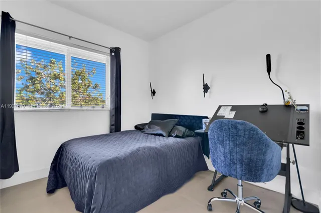 a bedroom with a bed tv and window