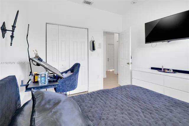 a bedroom with a bed and a flat screen tv
