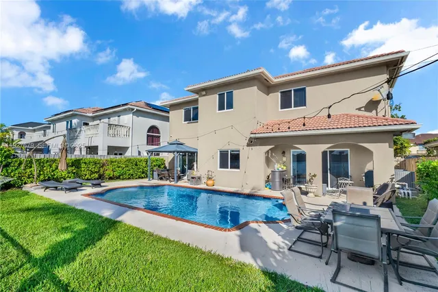 a view of a house with swimming pool and sitting area