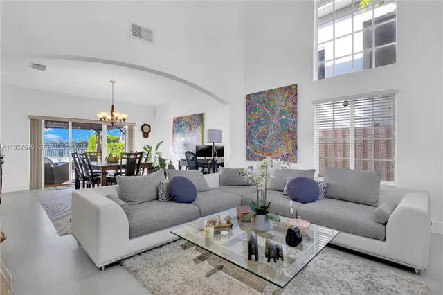 a living room with furniture ceiling fan and a window