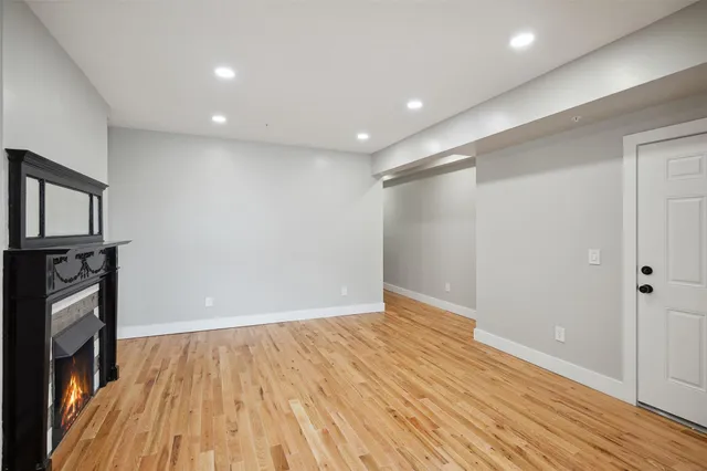 a view of empty room with wooden floor and fireplace