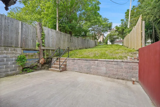a view of backyard with wooden fence and a bench