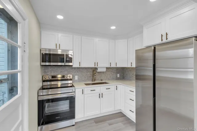 a kitchen with white cabinets and stainless steel appliances