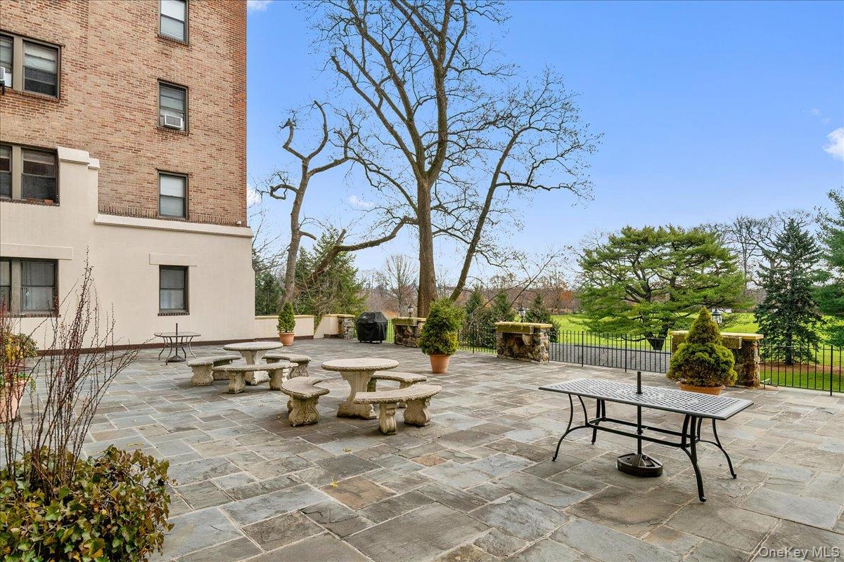 4784 Boston Post Road, Unit A 24 Pelham, NY 10803 - Photo 14 of 18 Expansive stone patio featuring multiple stone picnic tables, an integrated grill area, over looking country club golf course