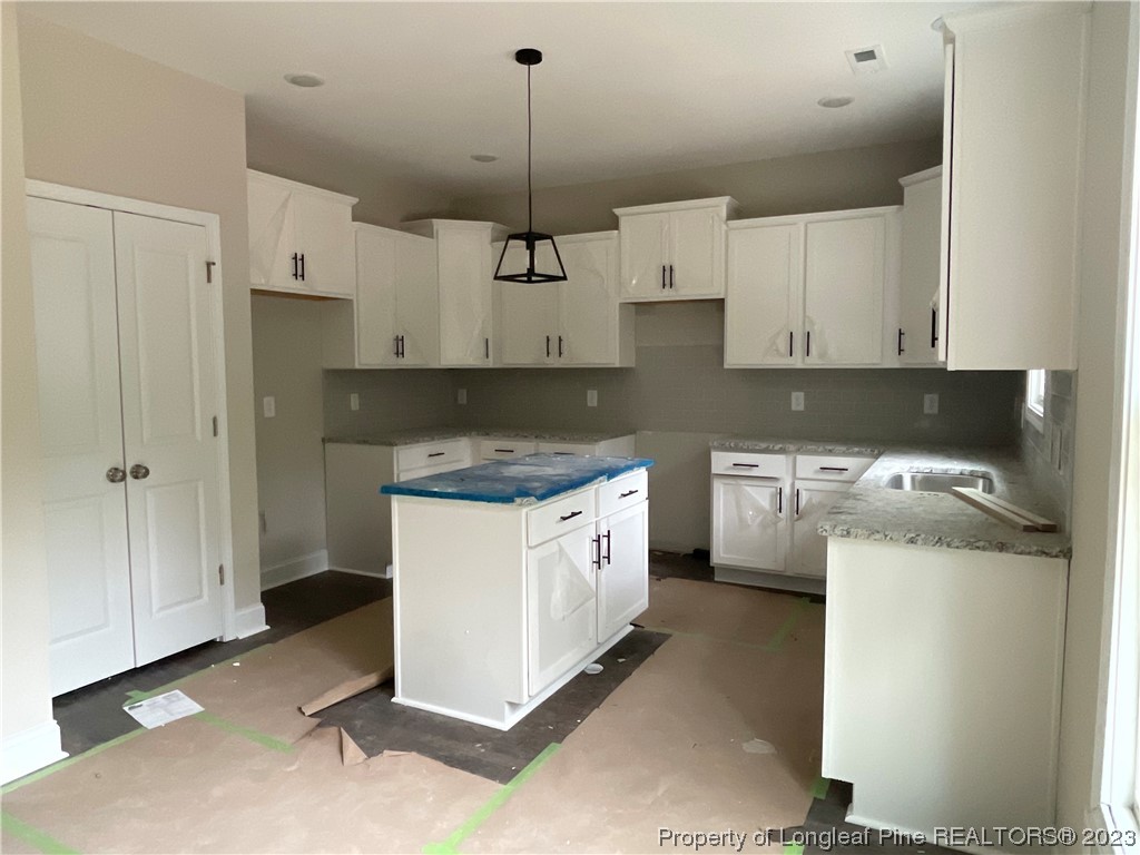 61 Solomon Drive Cameron, NC 28326 - Photo 2 of 7 a kitchen with a stove a refrigerator and white cabinets
