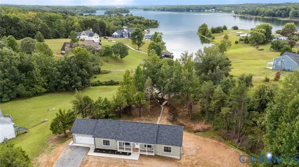 an aerial view of a house with a yard lake lake view and mountain view