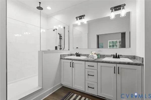 a spacious bathroom with a double vanity sink a mirror and shower