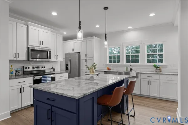 a kitchen with a center island appliances and cabinets