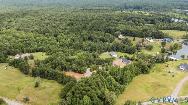 an aerial view of a house with a yard and lake view