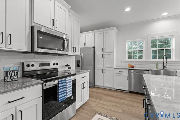 a kitchen with stainless steel appliances granite countertop a stove a sink dishwasher a refrigerator and a microwave