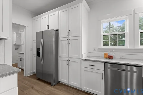 a kitchen with stainless steel appliances granite countertop a refrigerator and a sink