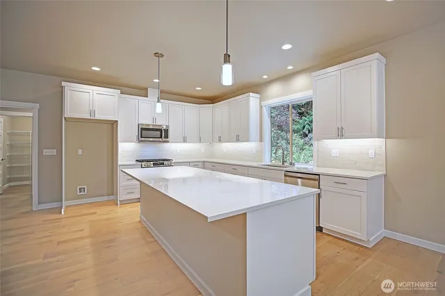 a kitchen with kitchen island a sink stainless steel appliances and cabinets