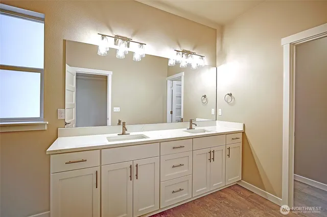 a bathroom with a double vanity sink and a mirror