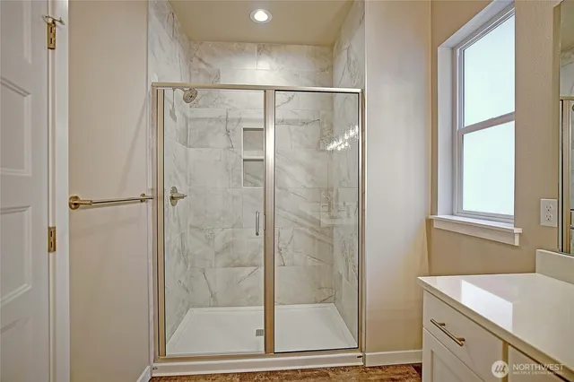 a bathroom with a shower and a sink a mirror