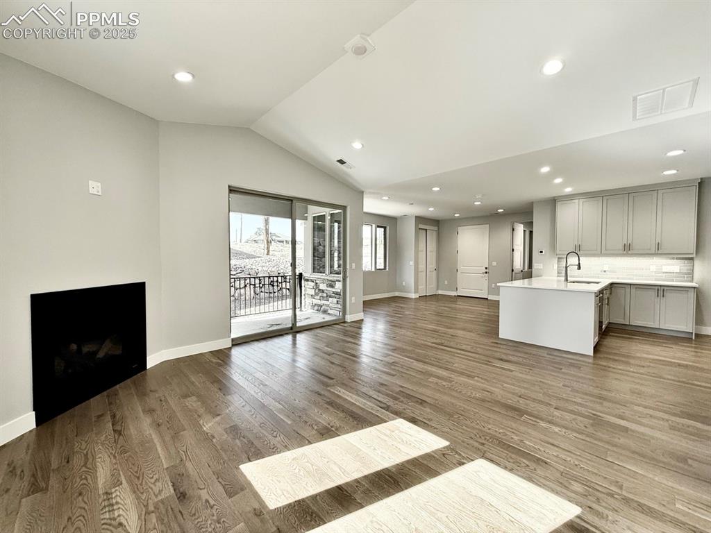 3155 Promise Point Colorado Springs, CO 80921 - Photo 14 of 26 a view of a living room a kitchen with wooden floor and a sink