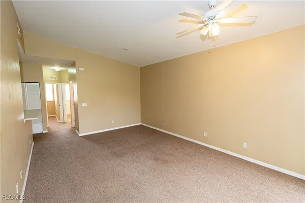 an empty room with a ceiling fan and a bathroom