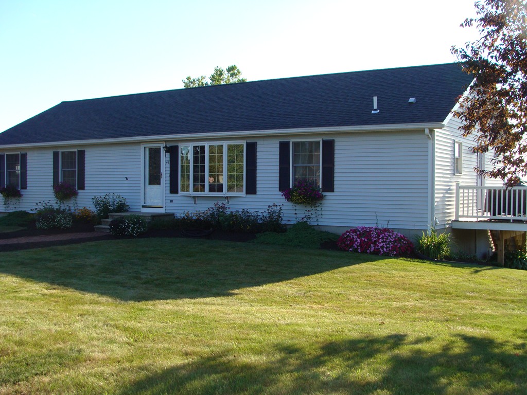 a front view of a house with garden and yard