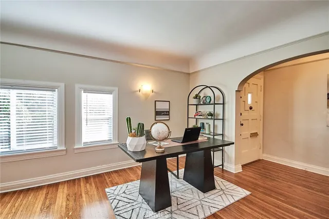 a dining room with furniture potted plants and wooden floor