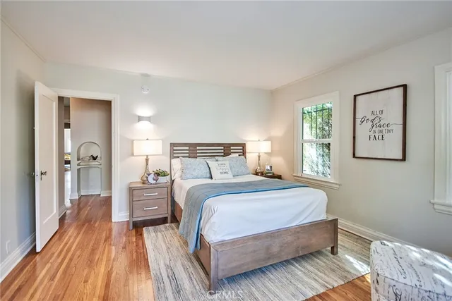 a bedroom with a bed and wooden floor