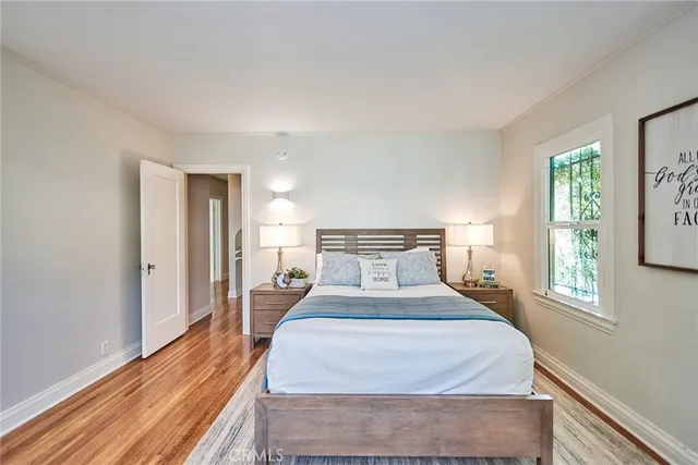 a bedroom with a bed and wooden floor