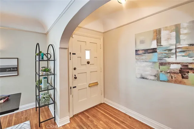a living room with furniture hard wood floor and a table