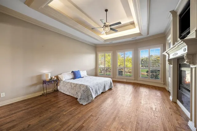 a bedroom with a bed tv and wooden floor