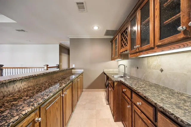 a kitchen with granite countertop sink and cabinets