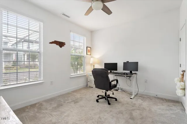 a view of a workspace with furniture and a window