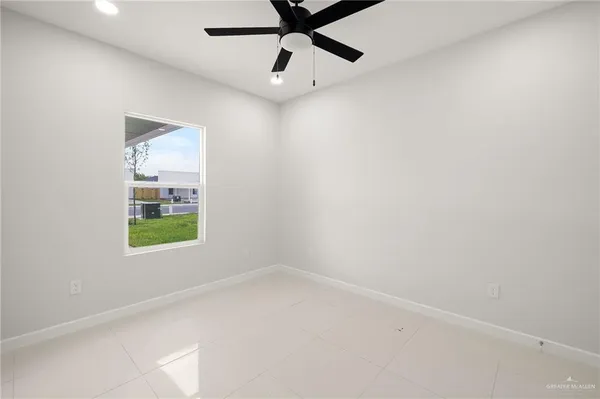 an empty room with a window and a fan