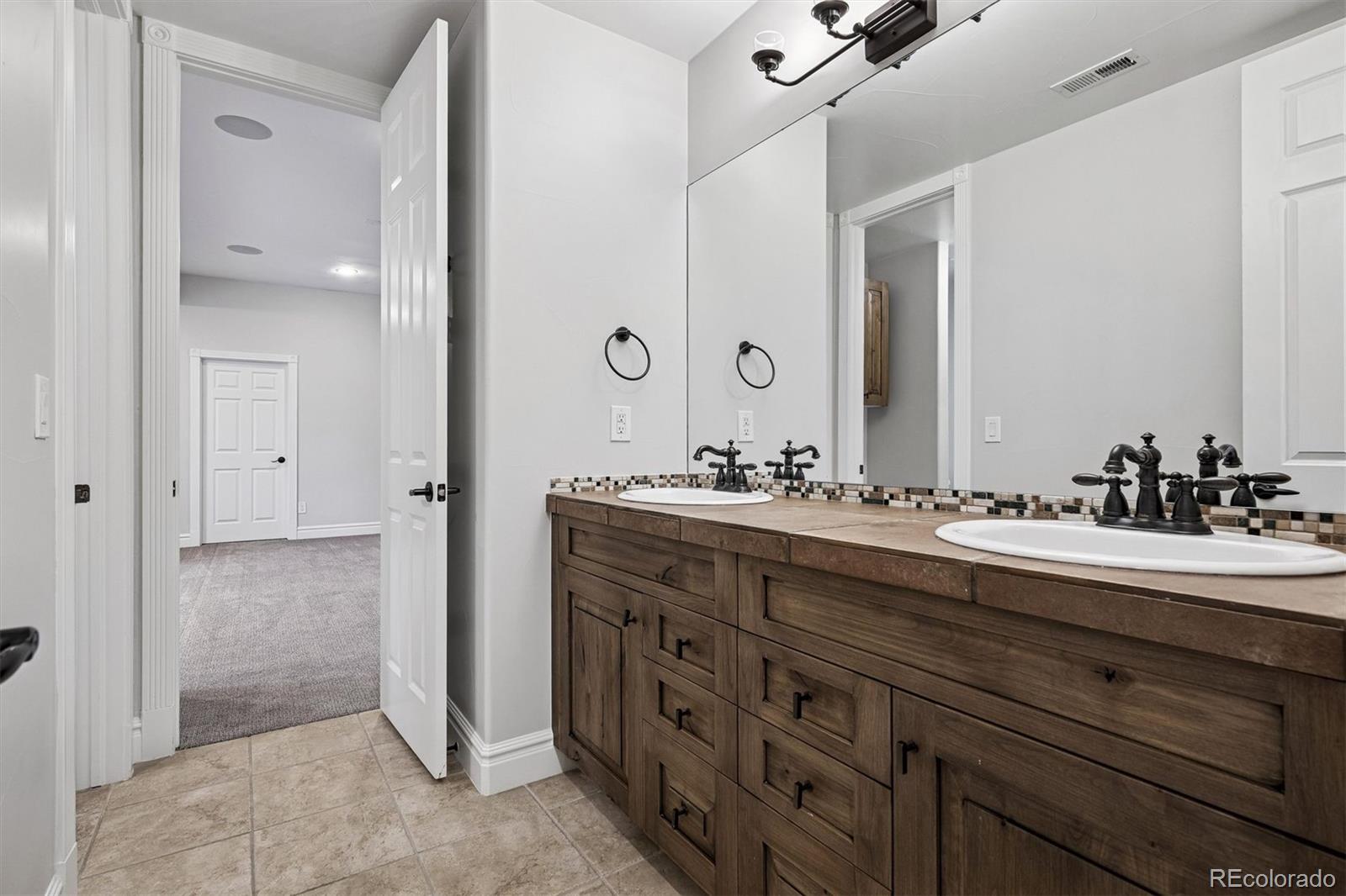 337 High Ridge Way Castle Pines, CO 80108 - Photo 44 of 50 a spacious bathroom with a double vanity sink a mirror and a shower