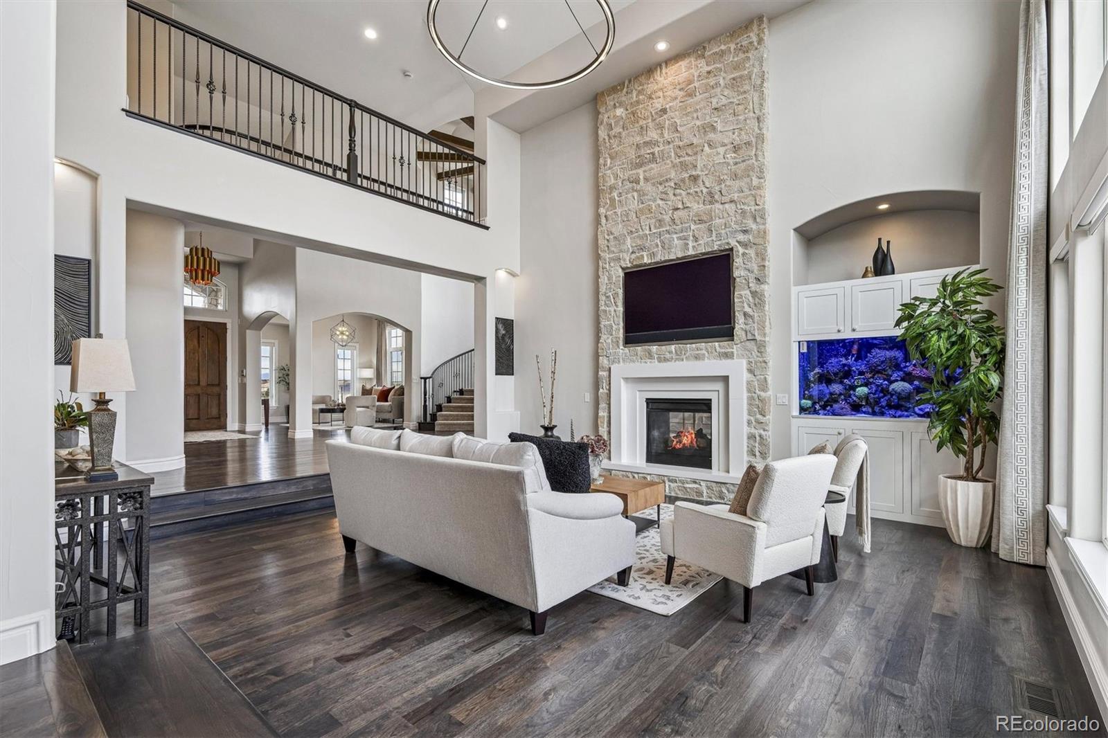337 High Ridge Way Castle Pines, CO 80108 - Photo 9 of 50 a living room with furniture a fireplace and a flat screen tv