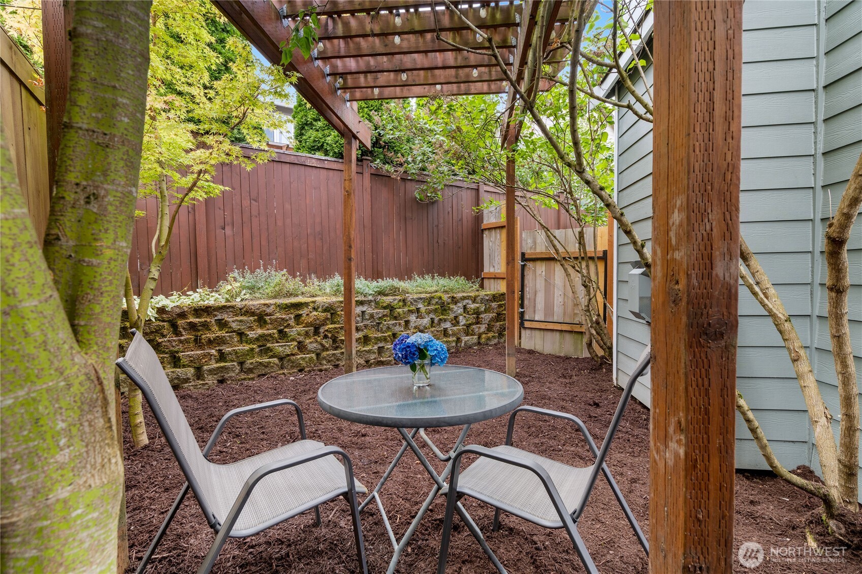 21104 1st Avenue West Bothell, WA 98021 - Photo 33 of 34 a backyard with table and chairs with wooden fence and plants